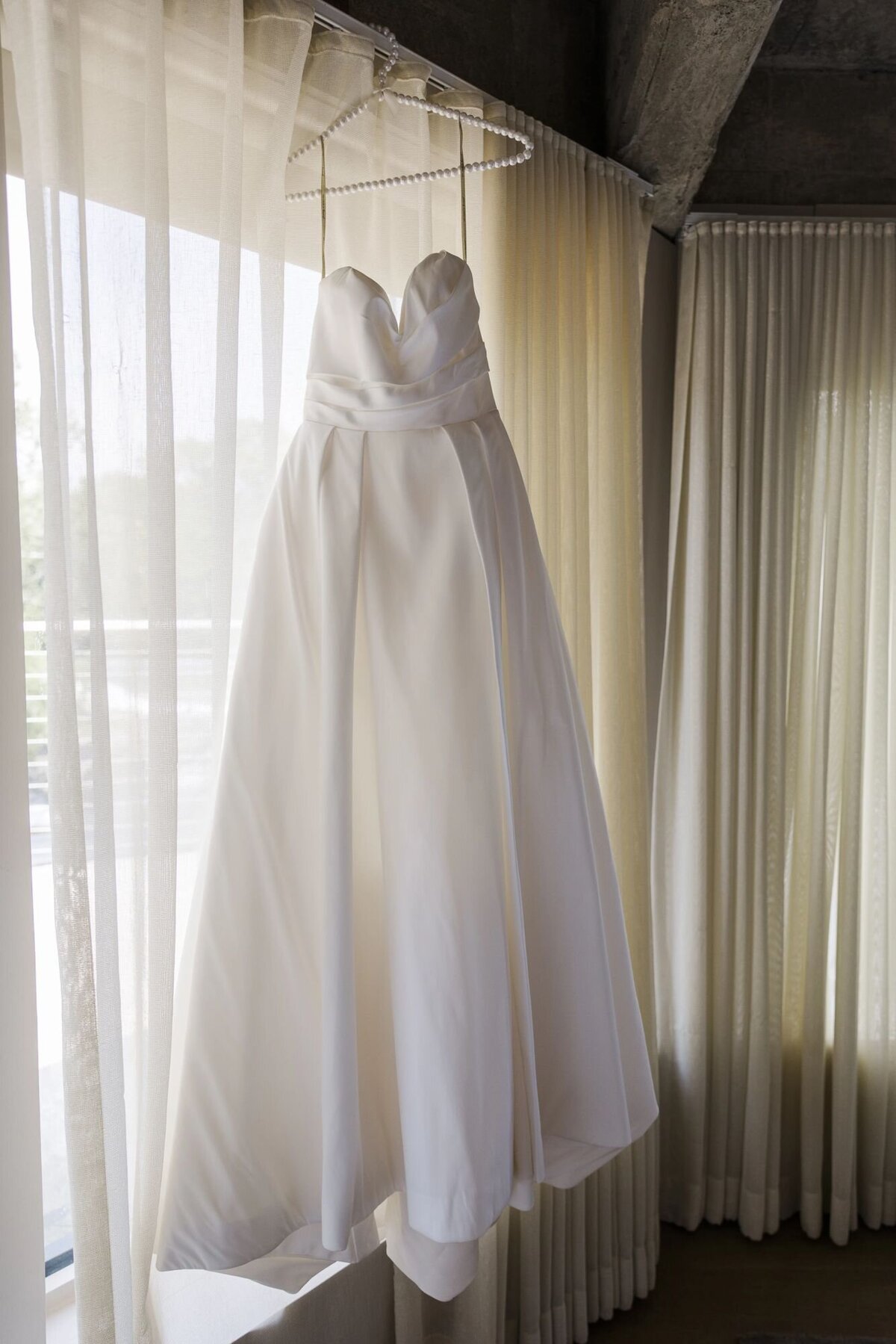Wedding dress hangs on the window in the bridal suite at The Roundhouse in Beacon NY