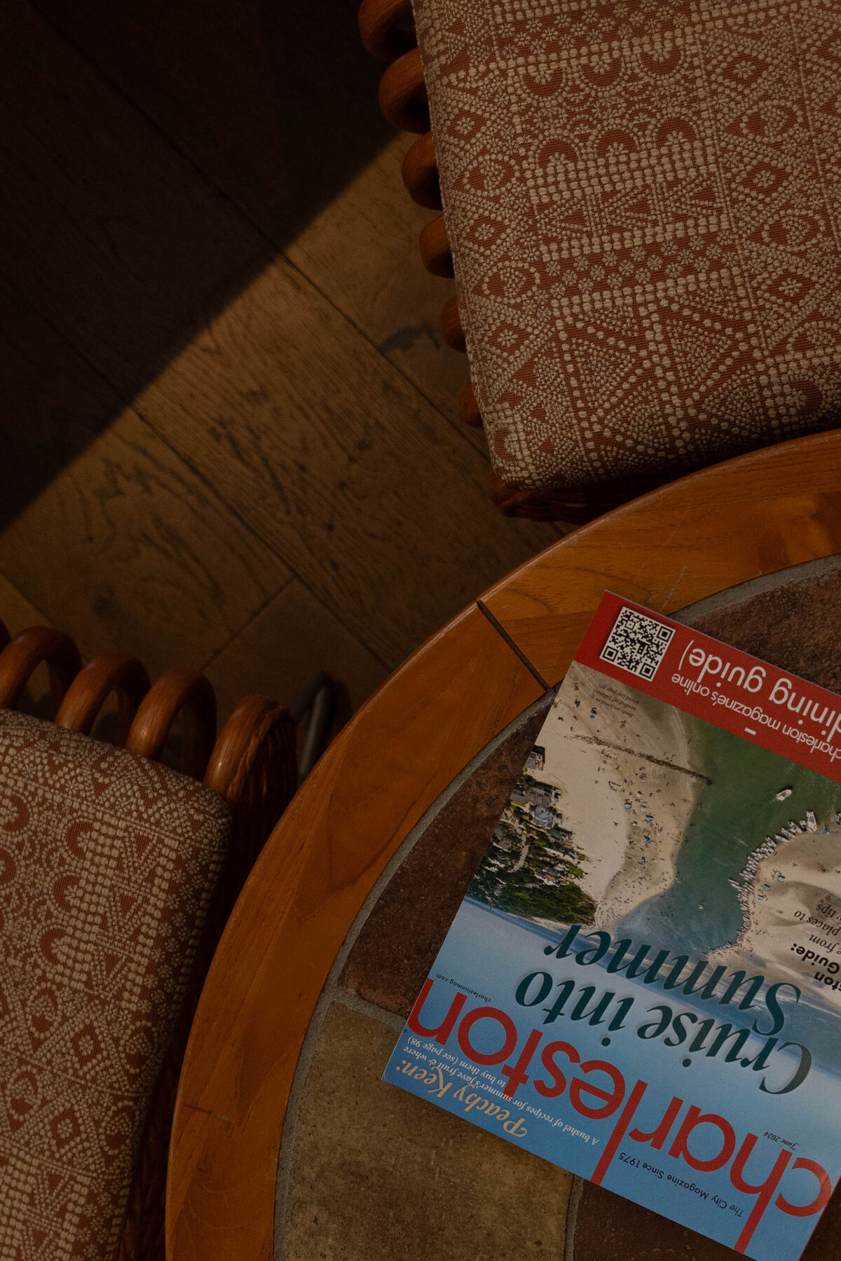 Charleston Magazine resting on a coffee table with wicker chairs