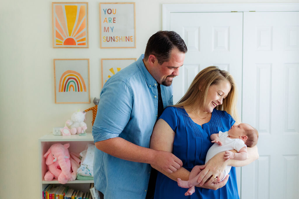 Two parents look at their newborn.