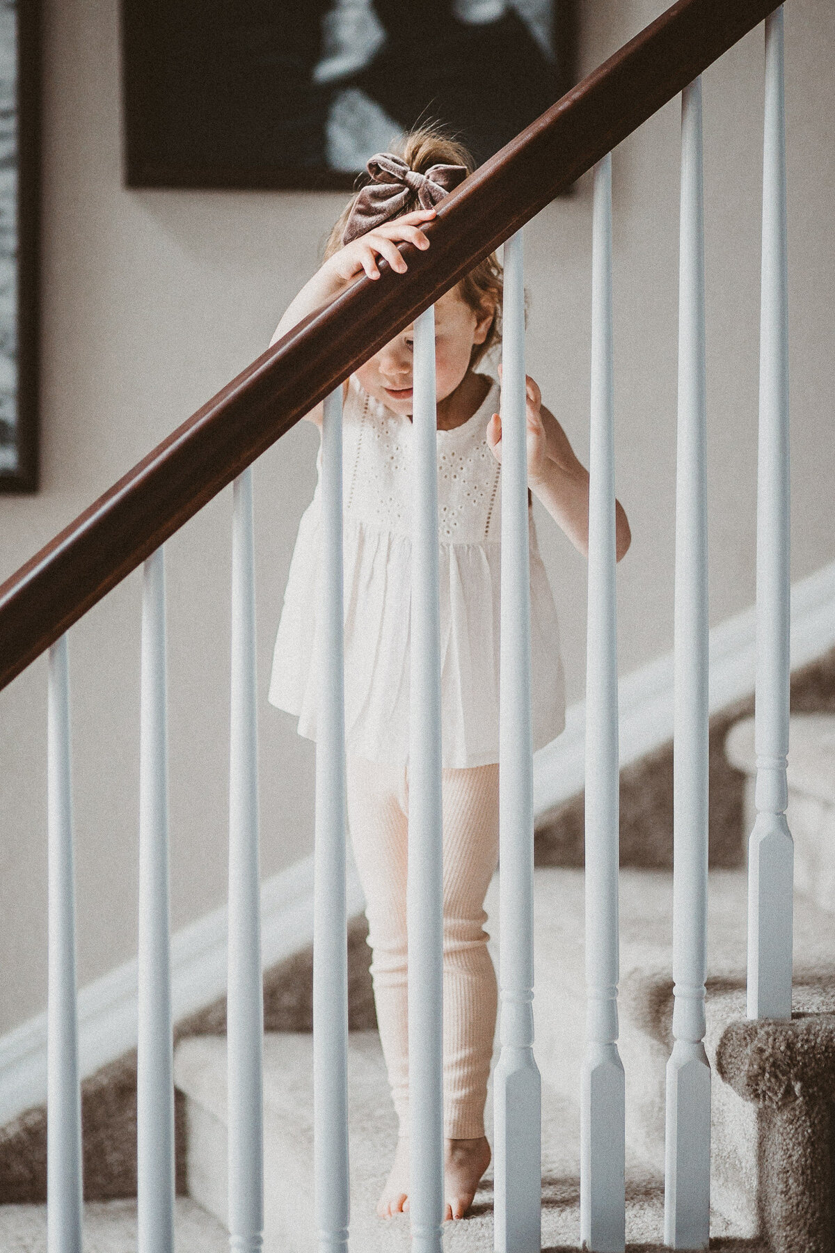 child tiptoes up stairs in her home