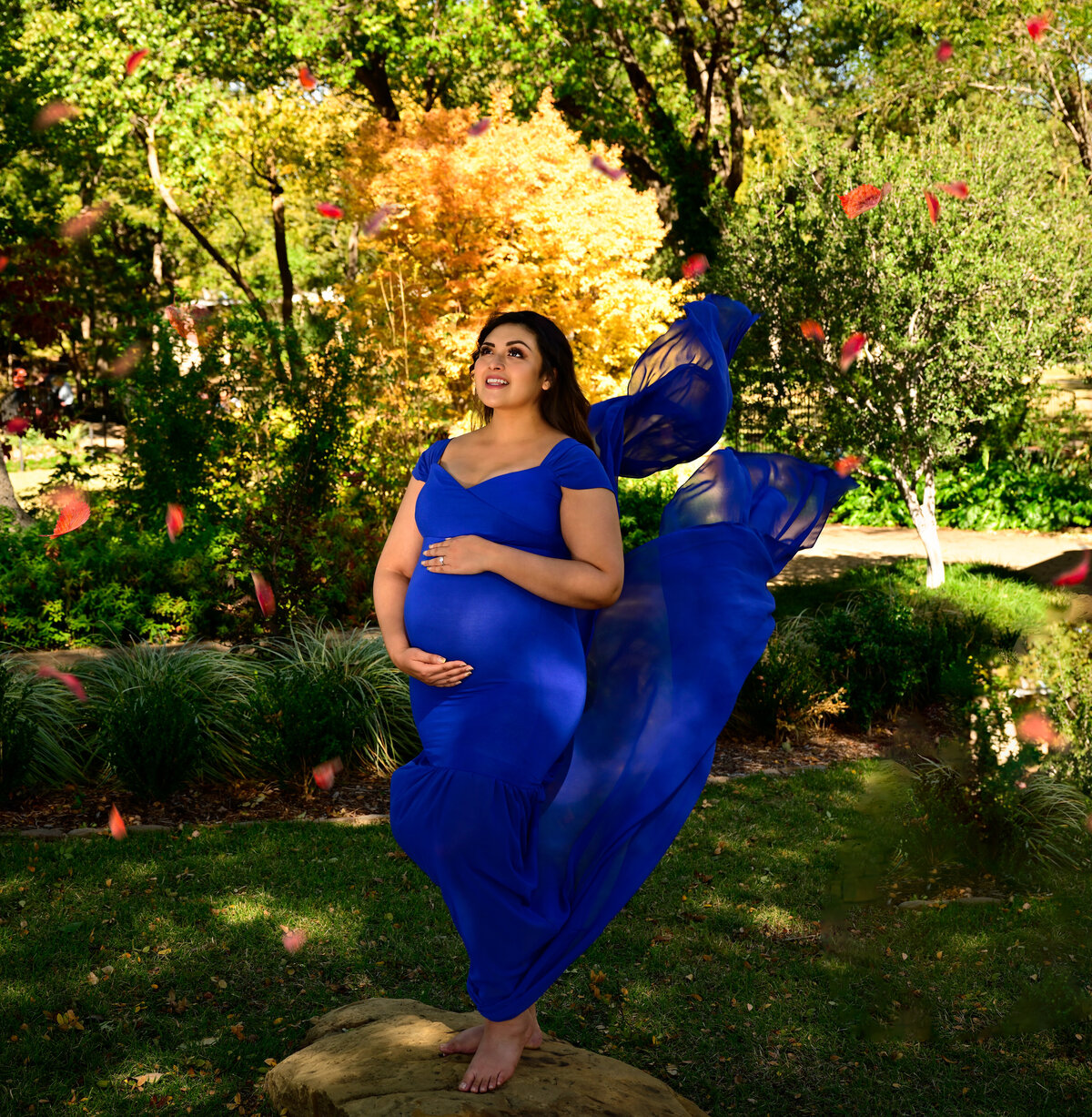 Maternity photo session in the fall breeze with leaves gently blowing by. Image photographed by Beth Benecki