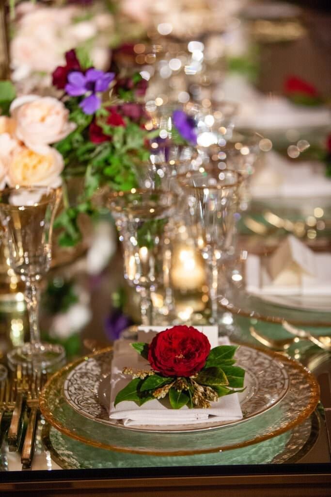 Flowers along a plate and table at a reception