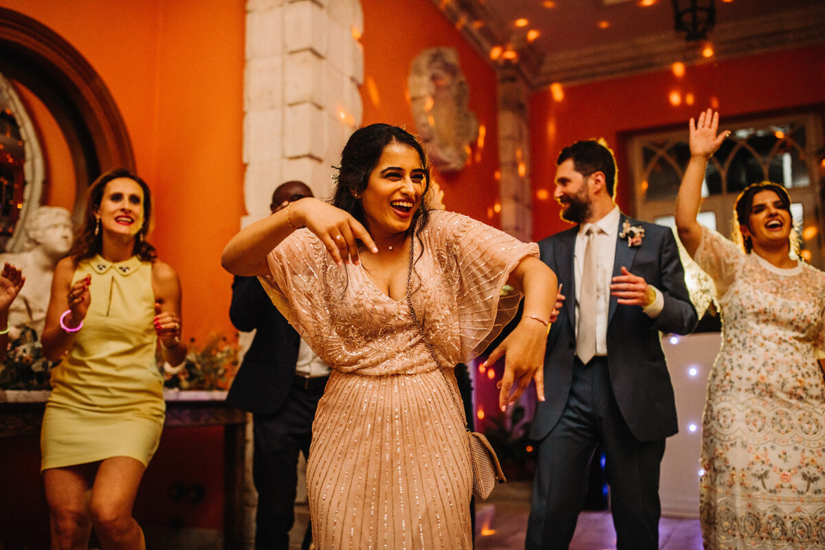 Wedding guests dancing at indoor wedding reception