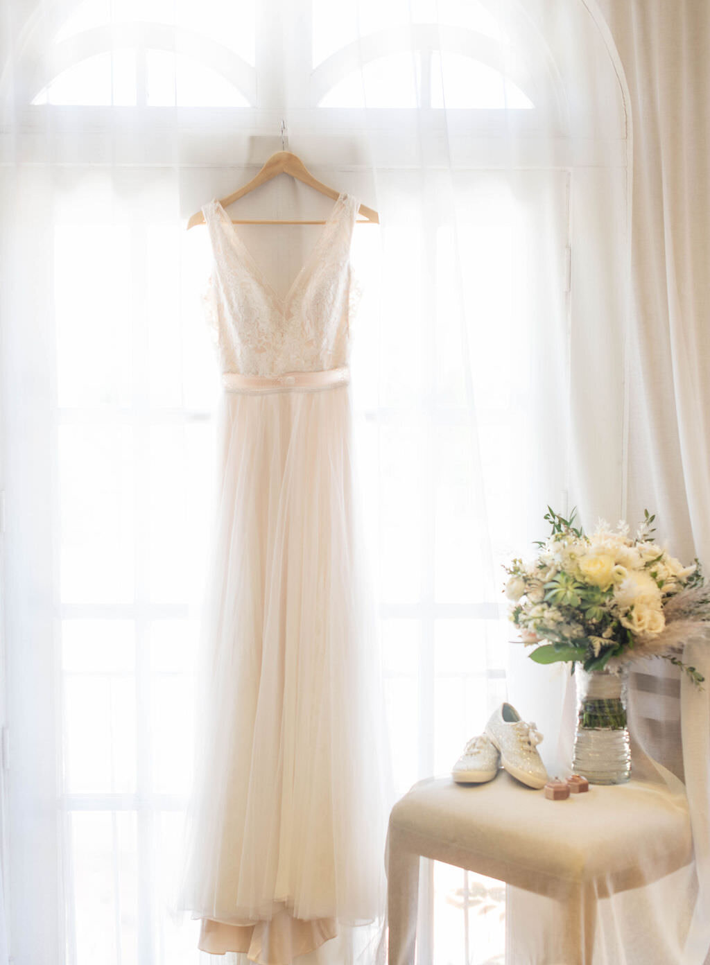 A white wedding dress hanging from a window