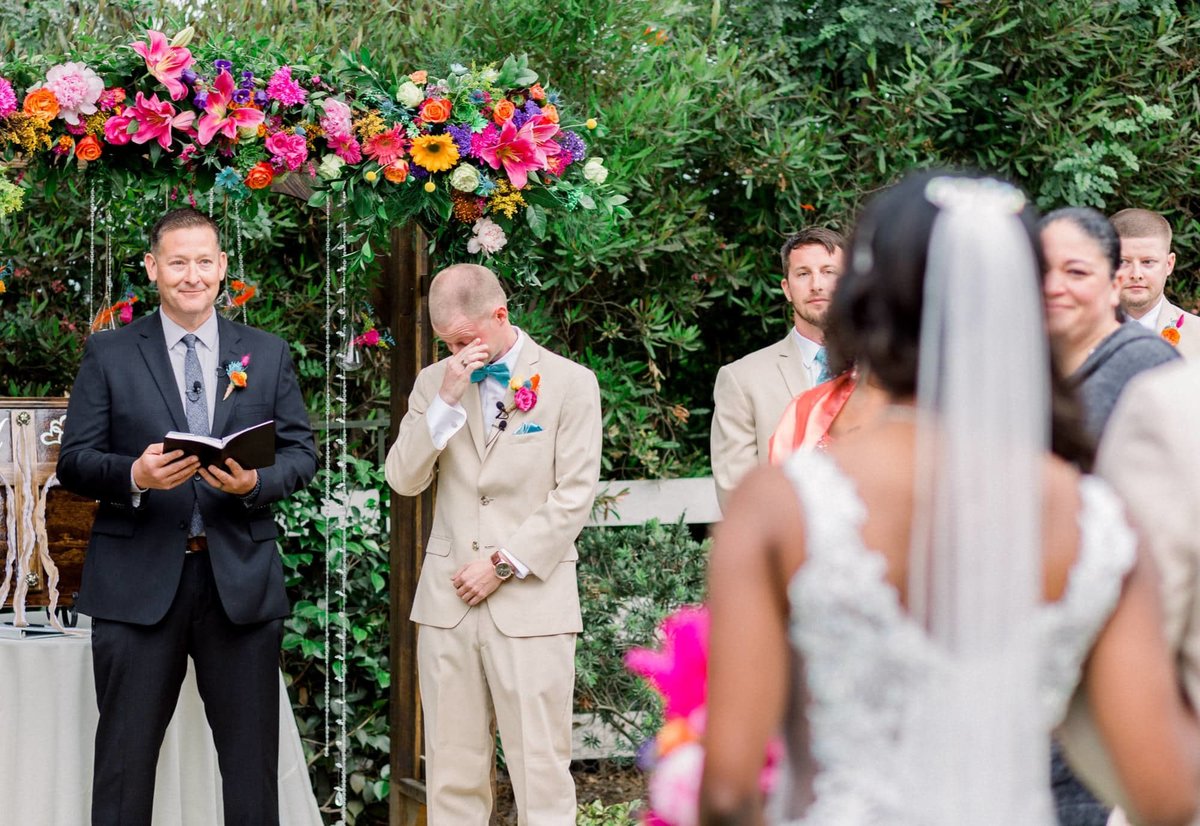 Groom stands at the altar wiping his tears as his Bride walks up the aisle towards him