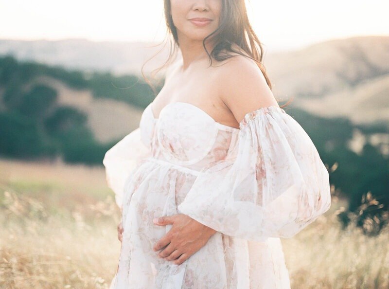 Pregnant woman framing her belly in a tulle dress taken by San Francisco Maternity Photographer Laurel Smith.
