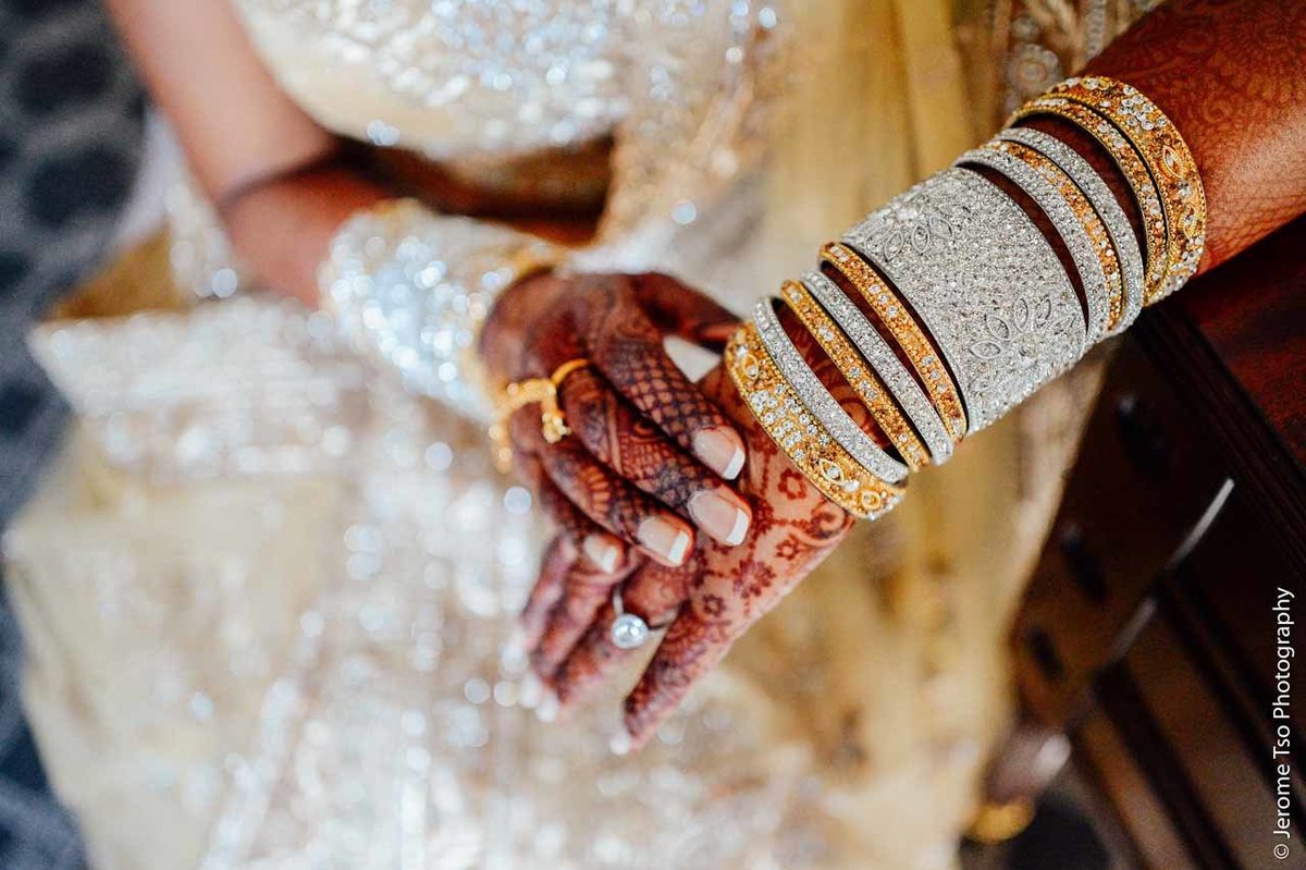 Indian bride with henna art and gold bangles