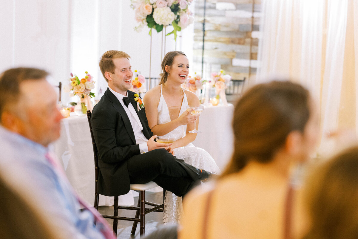 couple-laughing-sitting-together-for-wedding-toast