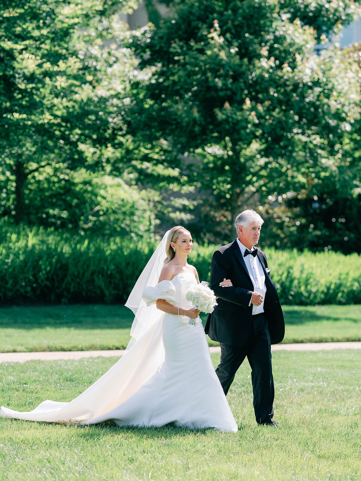 Bride and dad walk towards aisle