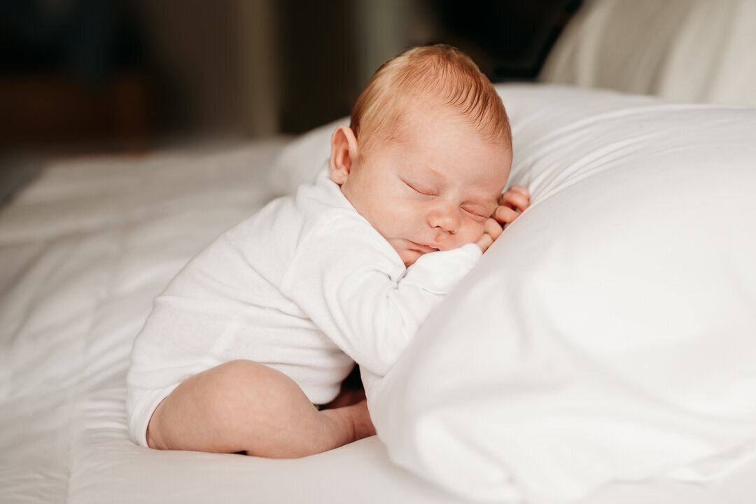 newborn baby resting on pillow