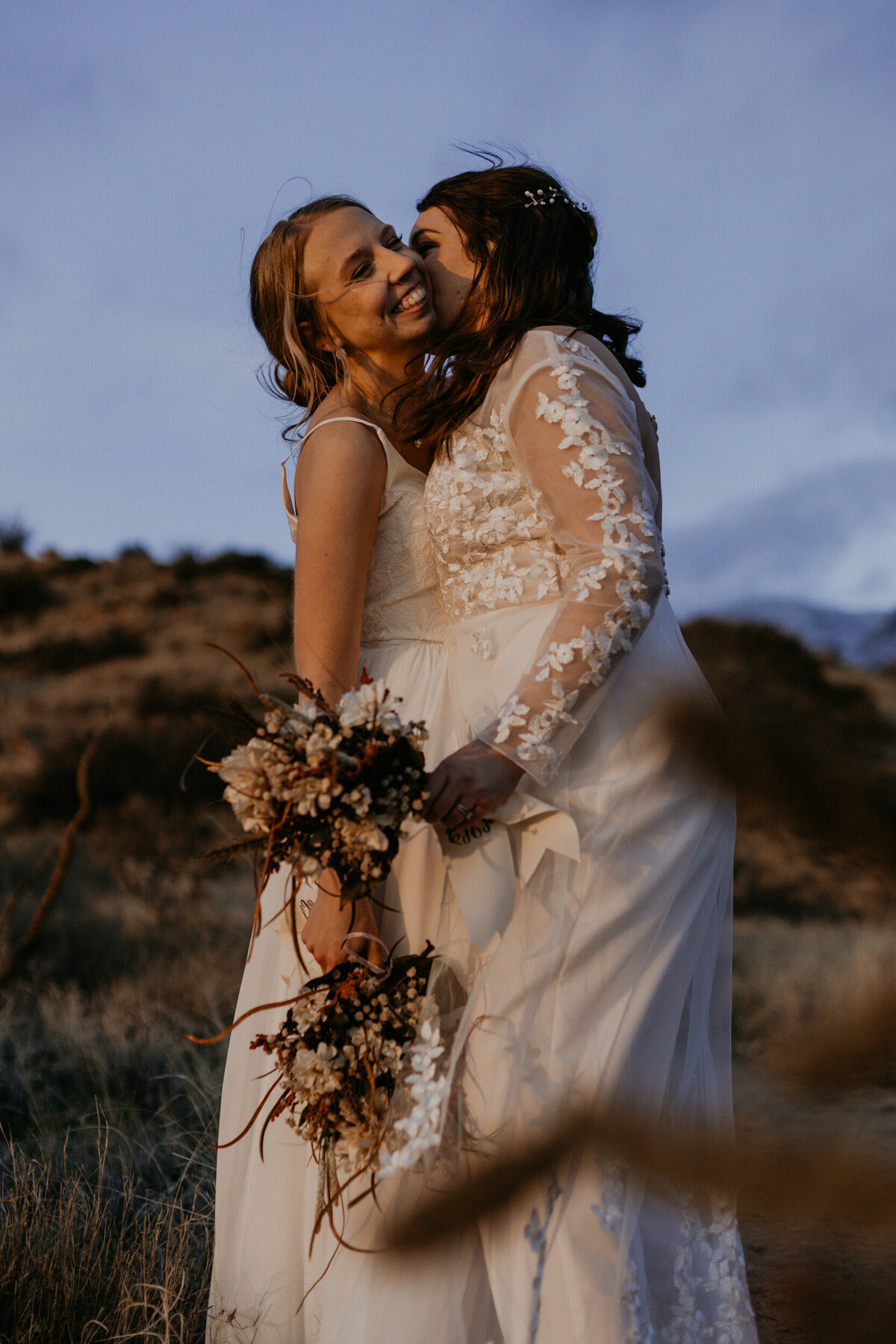 newlywed LGBTQ+ couple holding each other in front of the Sandia mountains in Albuquerque, New Mexico