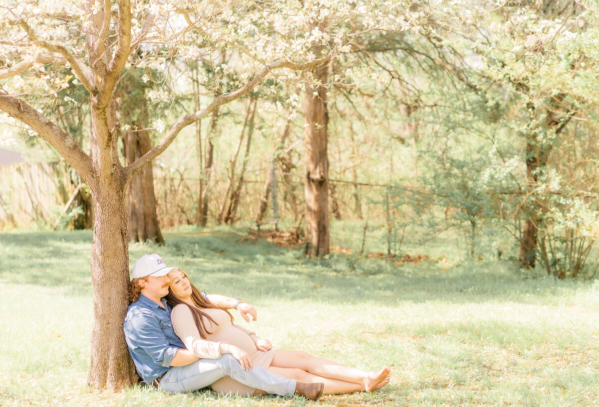 expectant parents relaxing under tree at their home in murfreesboro tn