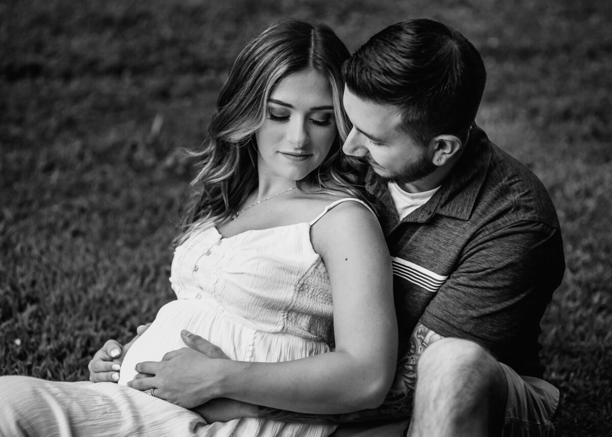 Pittsburgh maternity photographer captures black and white image of expecting couple in grass.