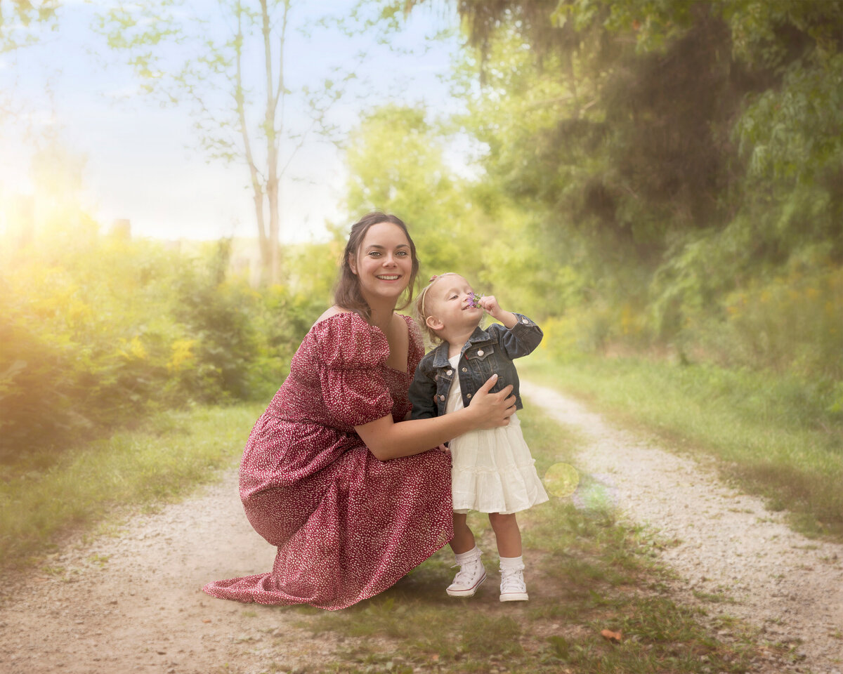 Whimsical outdoor portrait of a mother and daughter enjoying time together on a sunlit nature trail near Paris, Ontario. Photographed at Bronte Provincial Park in Oakville, Ontario.
