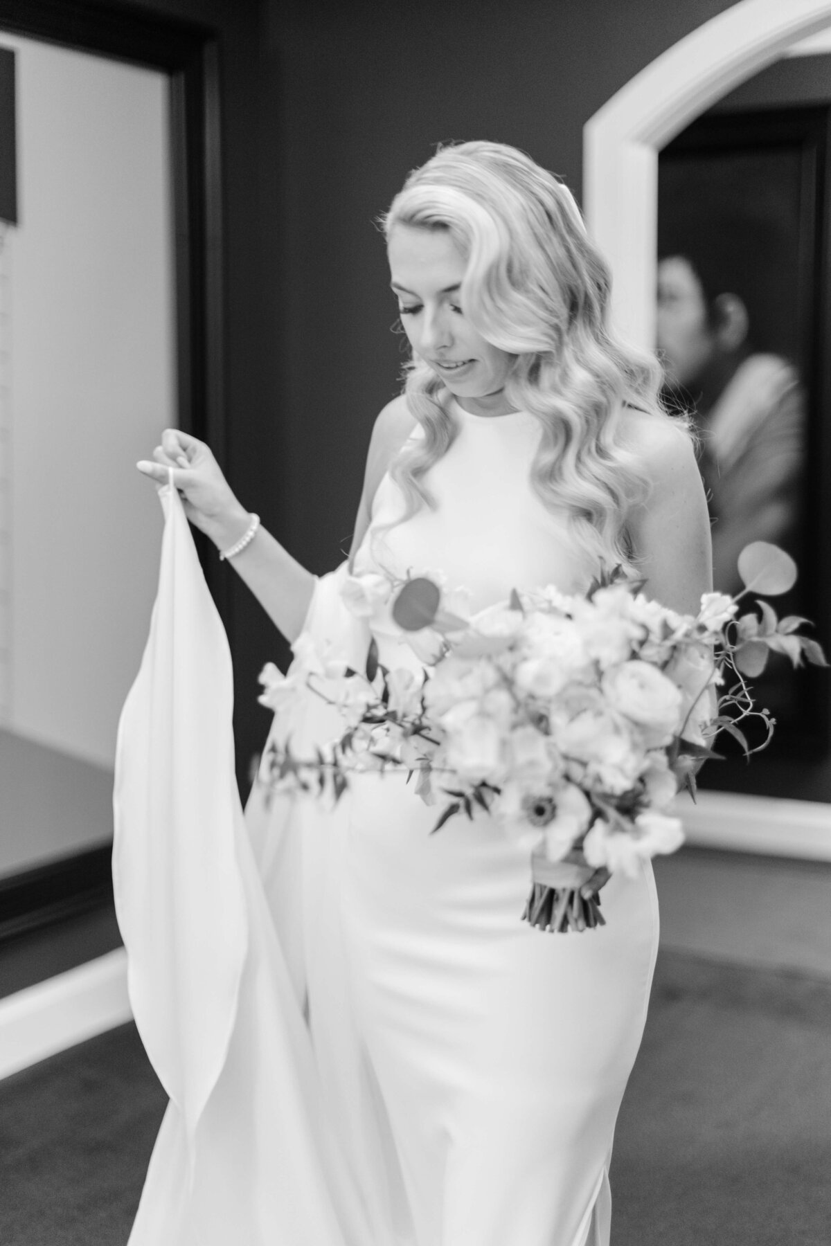 A bride walks while holding flowers.