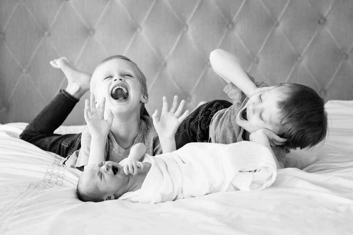 Black and white childrens portrait of three young children laughing