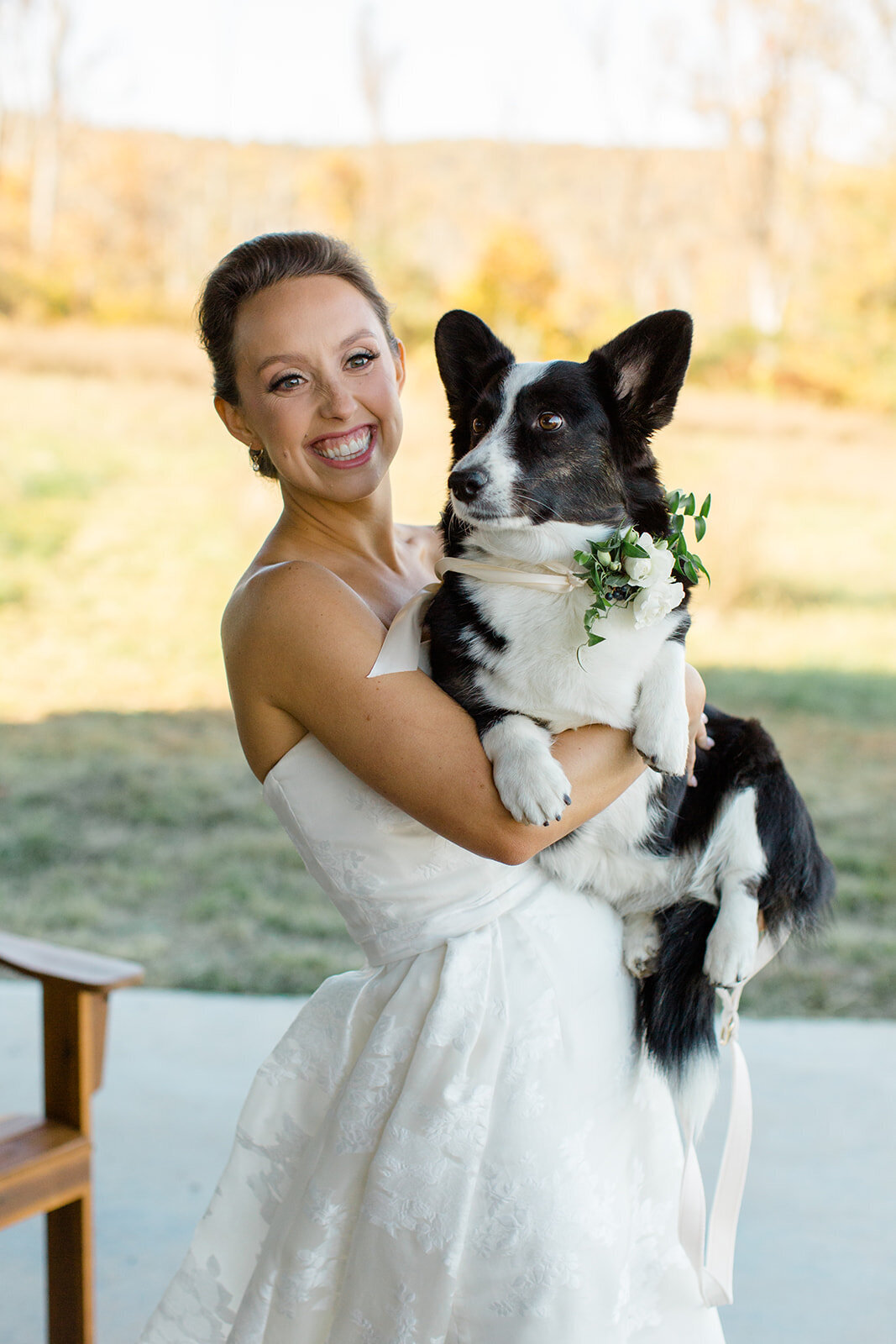 Bride smiling while carrying her dog