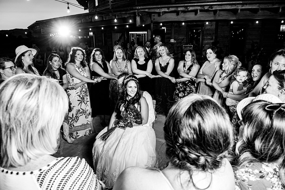 Black and white photo of bride and groom surrounded by her sorority sisters who are serenading them