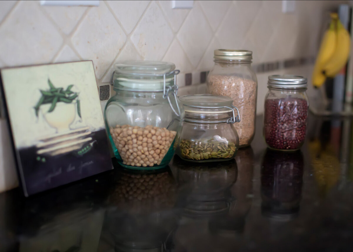 An image of glass jars on a kitchen counter filled with colorful beans and grains taken by a South Shore MA branding photographer.