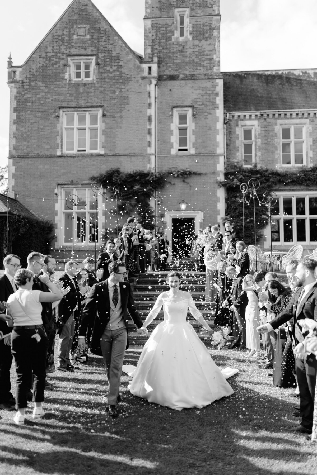 confetti being thrown at the couple with thicket priory in the background