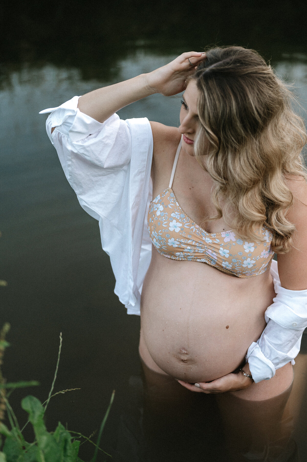 Pregnant mother poses in the water of a quiet stream