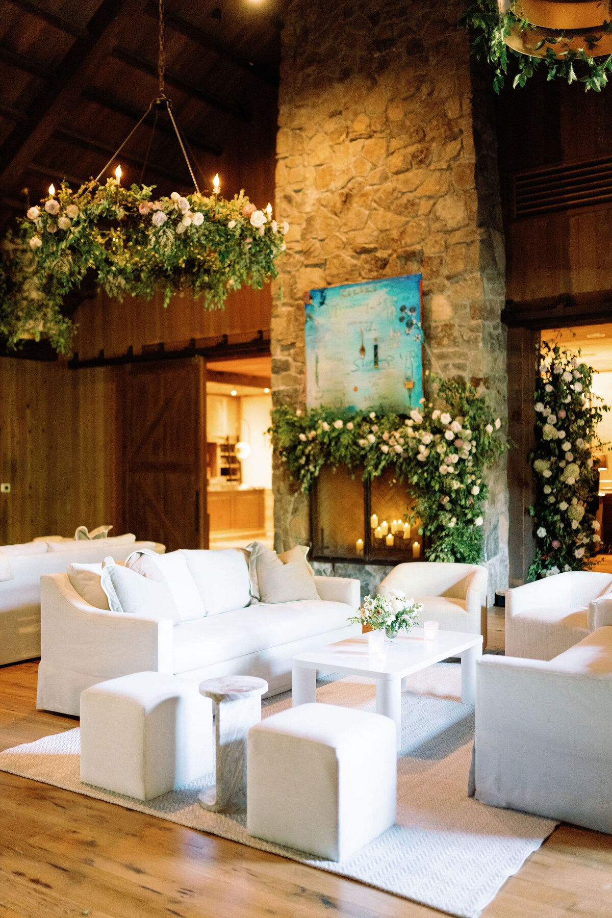 Lush garden inspired floral design growing in Bramble at Blackberry Farm for fall wedding reception. Growing floral installations on chandeliers and ceiling beams create garden setting for fall wedding reception. Timeless and elegant floral design in hues of white, cream, blush, and natural greens. Large trees with floral moments for outdoor wedding reception. Destination wedding at Blackberry Farm. Design by Rosemary & Finch Floral Design in Nashville, TN.