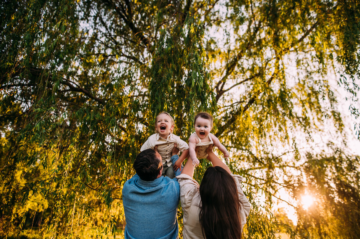 family of 4 under a willow tree at sunset