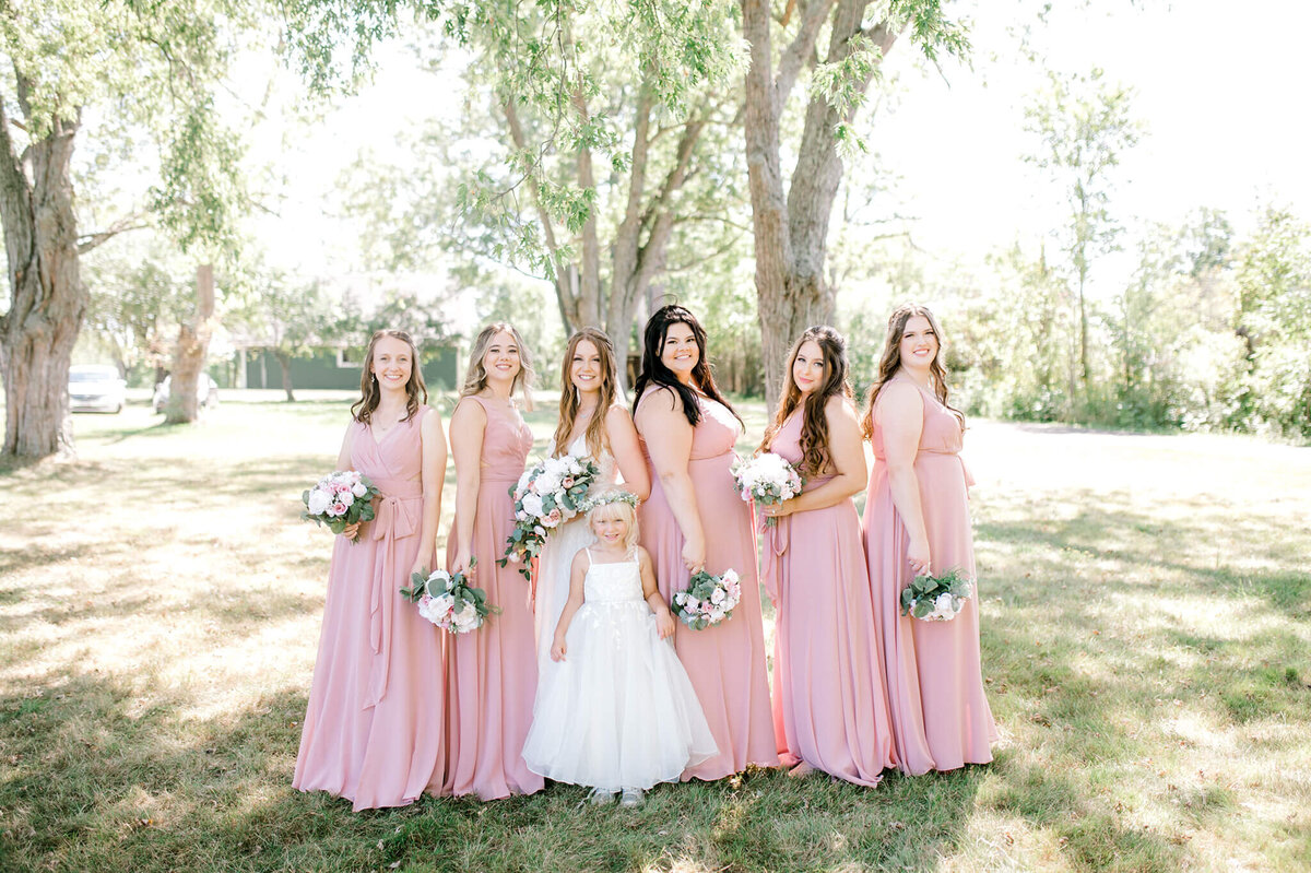 six bridesmaids with bouquets in hands looking at the camera.