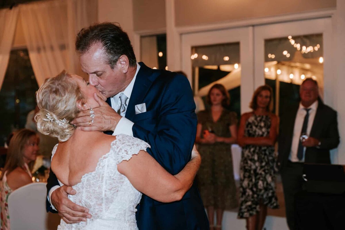 Groom kissing his bride during their first dance as husband and wife photographed by Ocala Wedding photographers