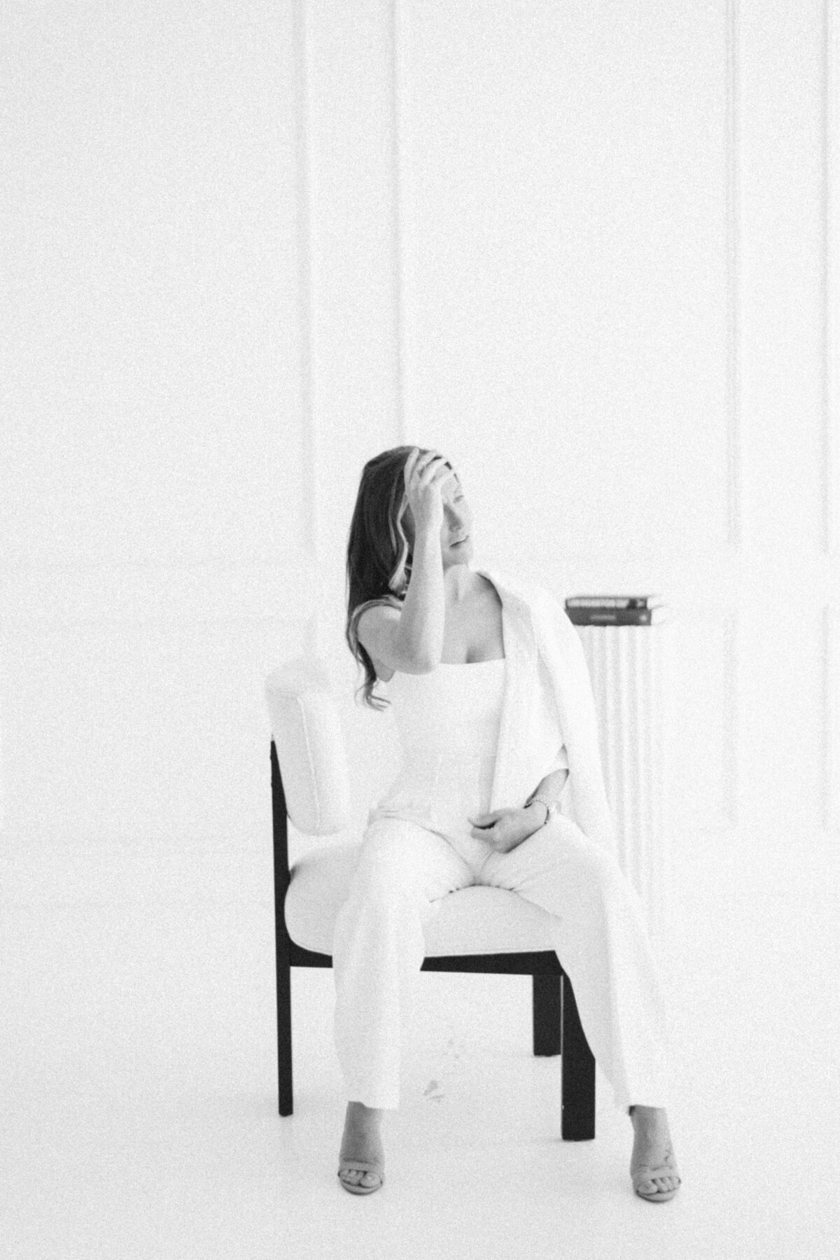 Black and white woman fixing hair in all white