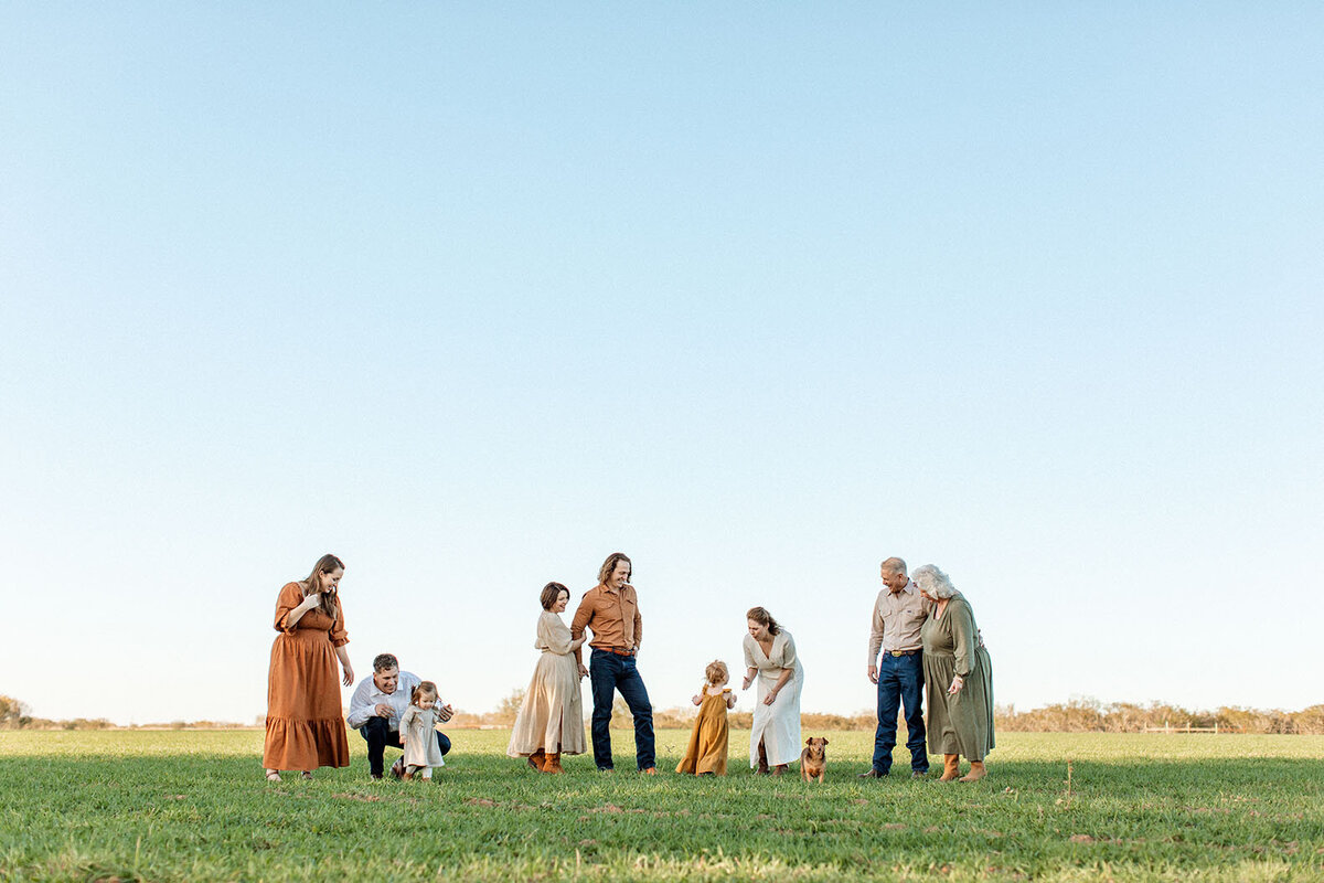 Large family gathered outdoors for a portrait session, captured by San Antonio photographer Sara James.