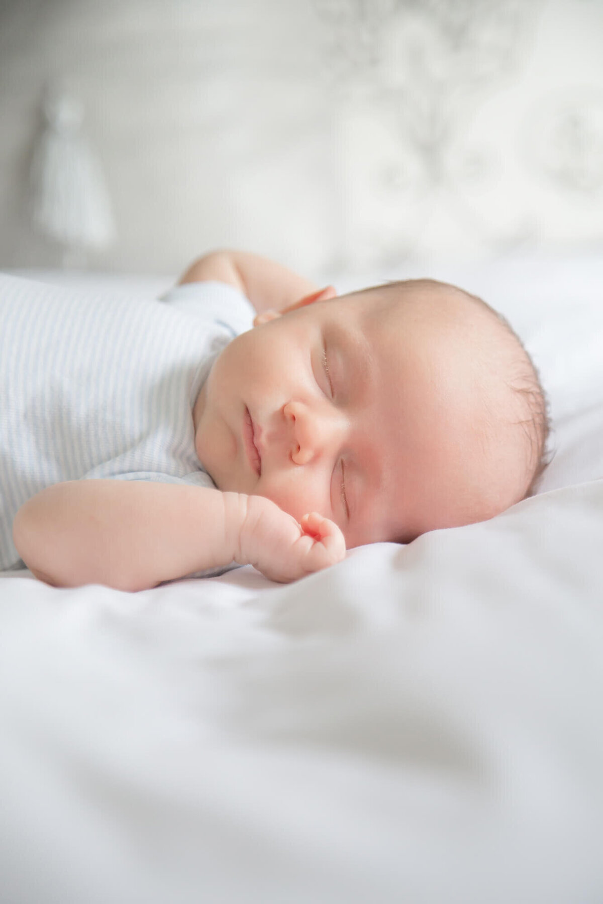 sweetly sleeping baby boy on a white bed