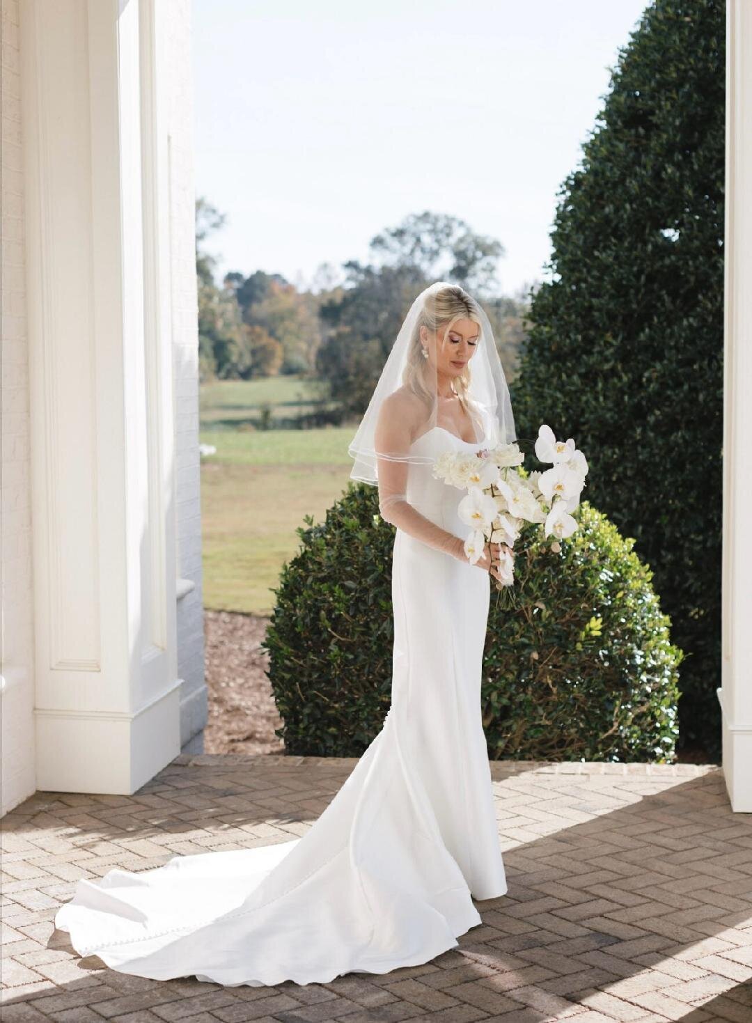 Stunning wedding portrait at Donovan Manor with a modern gown silhouette and orchid floral bouquet. 