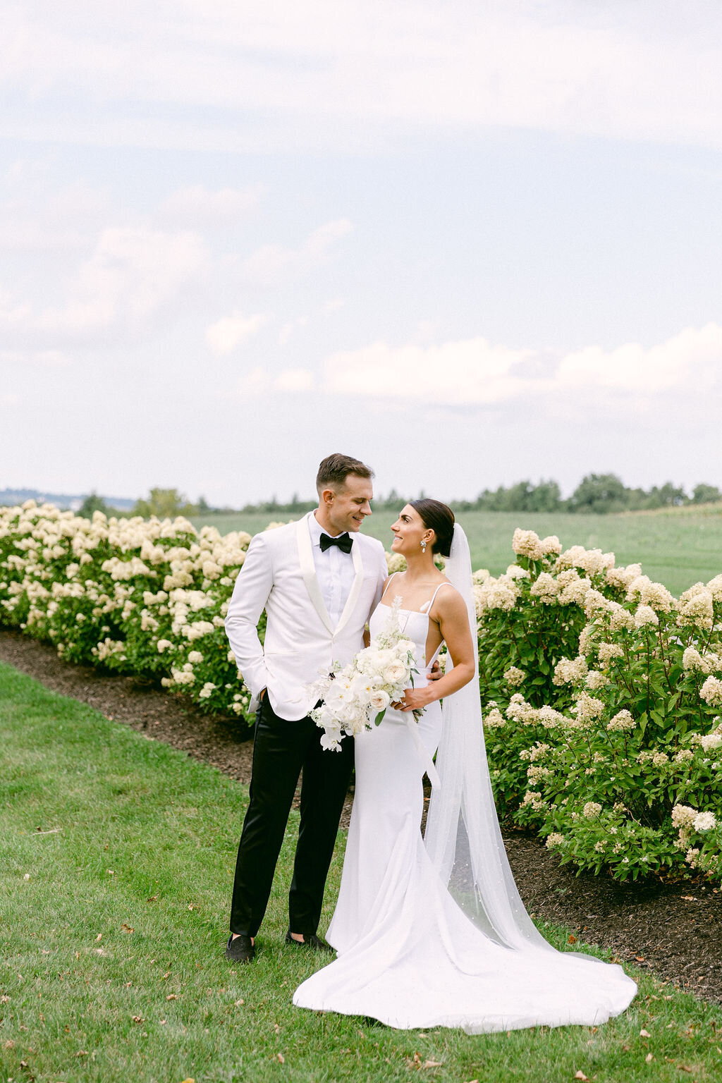 newlyweds-outside-hydrangeas-row-upstate