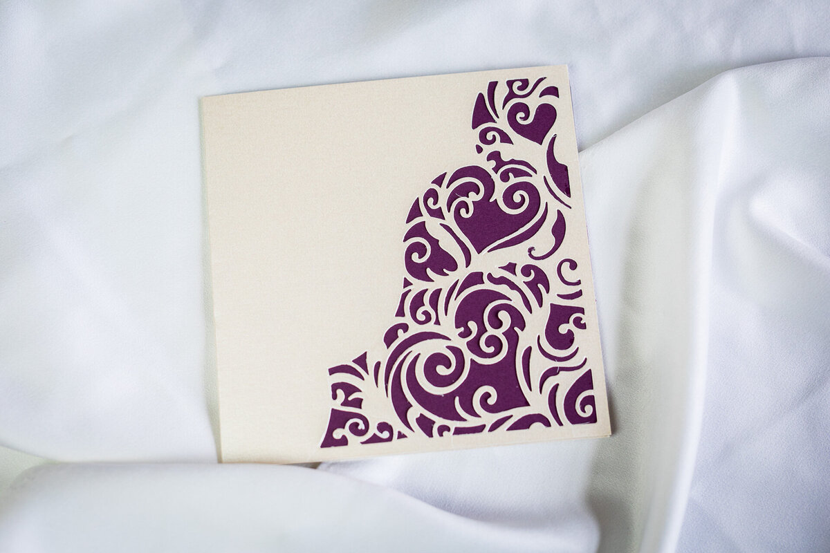 Purple and cream wedding invitation with a lacy heart design