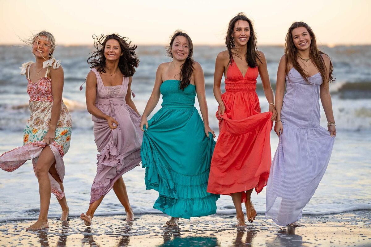 MBP Senior Team walking on the beach in long dresses in Lawrence, KS