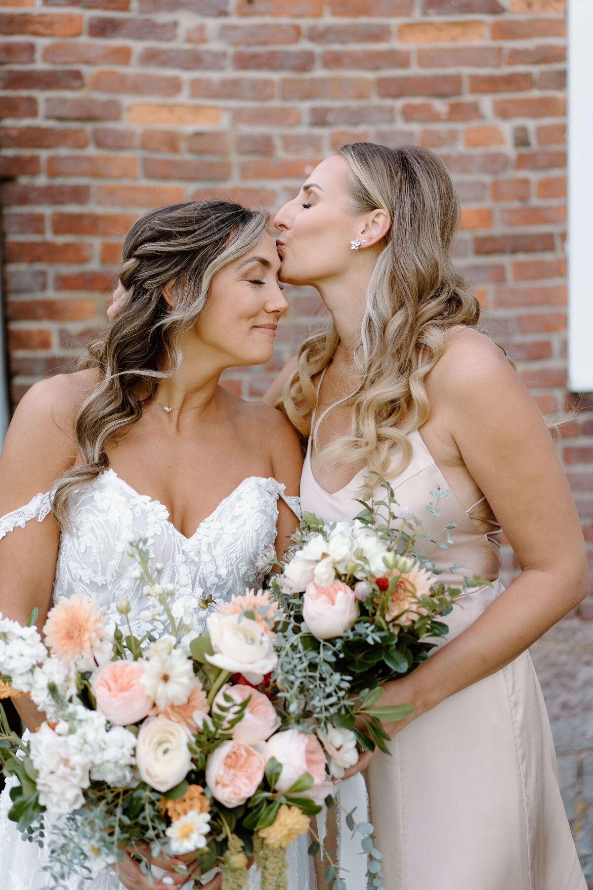 bride being kissed by a bridesmaid at lancaster, pa wedding