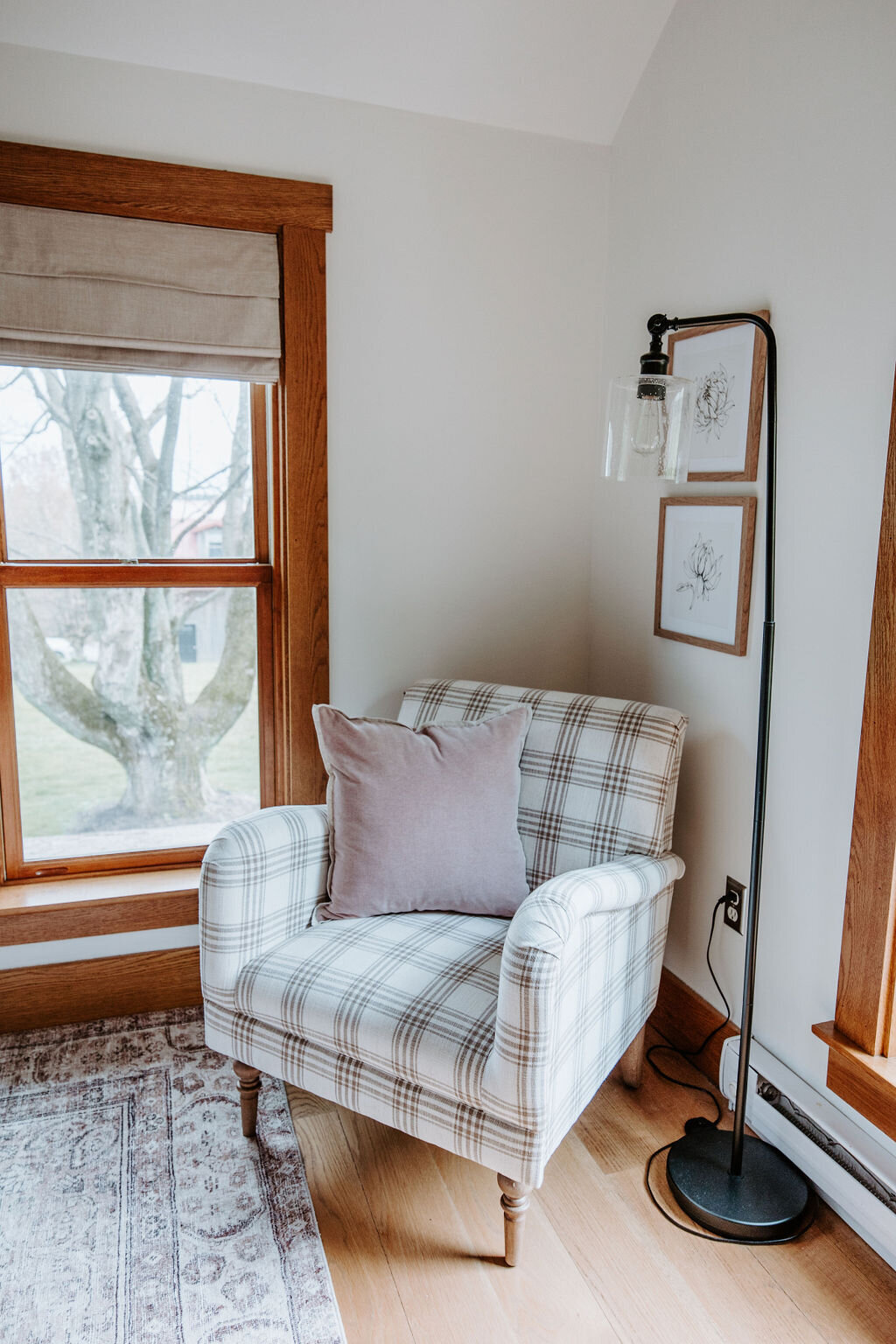 a plaid armchair with rose velvet West Elm pillow  in the bedroom of the modern farmhouse overnight accommodation at Willowbrook wedding venue