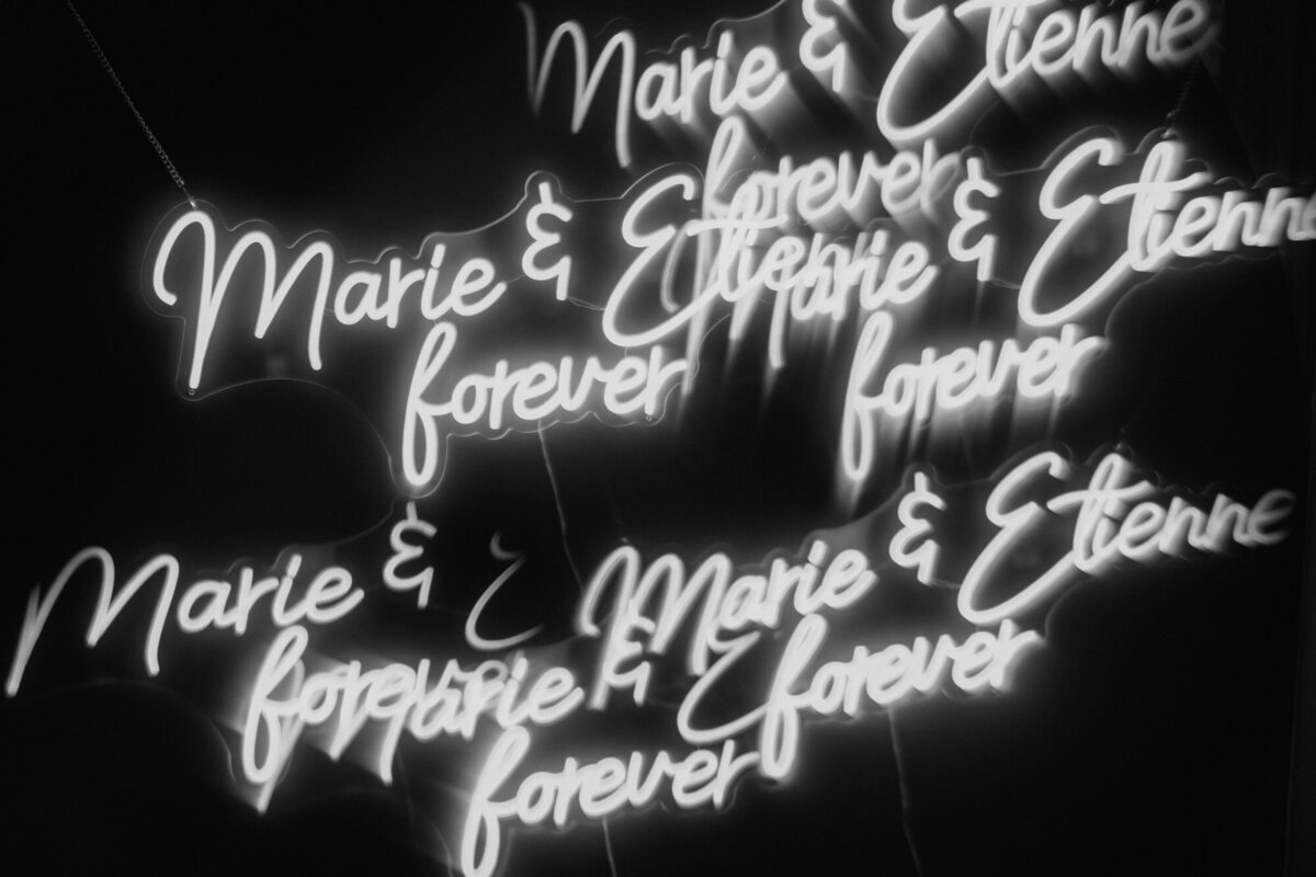 The neon sign says the names of the wedding couple plus forever.