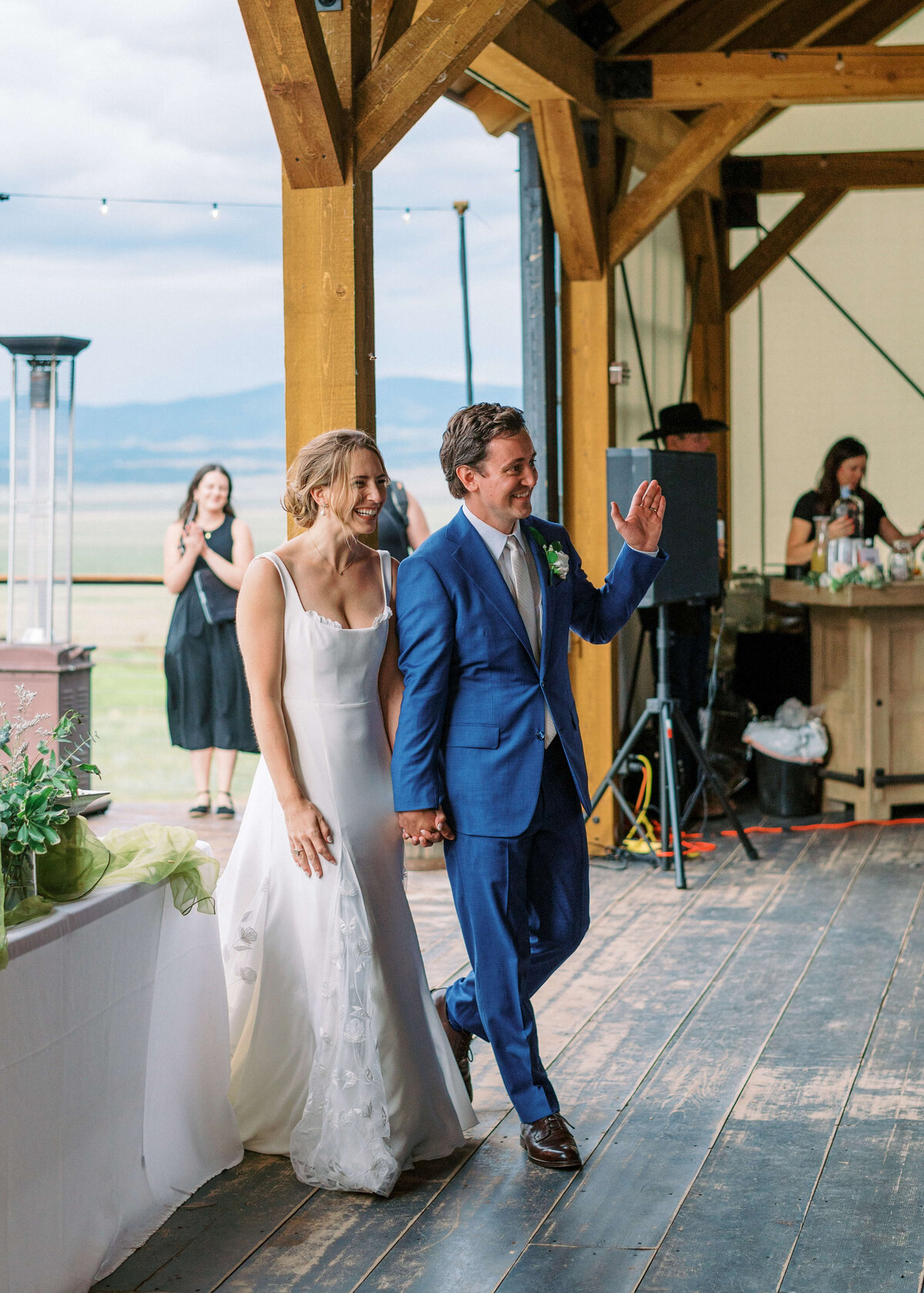 Bride and Groom walk into their outdoor reception together while being announced as husband and wife