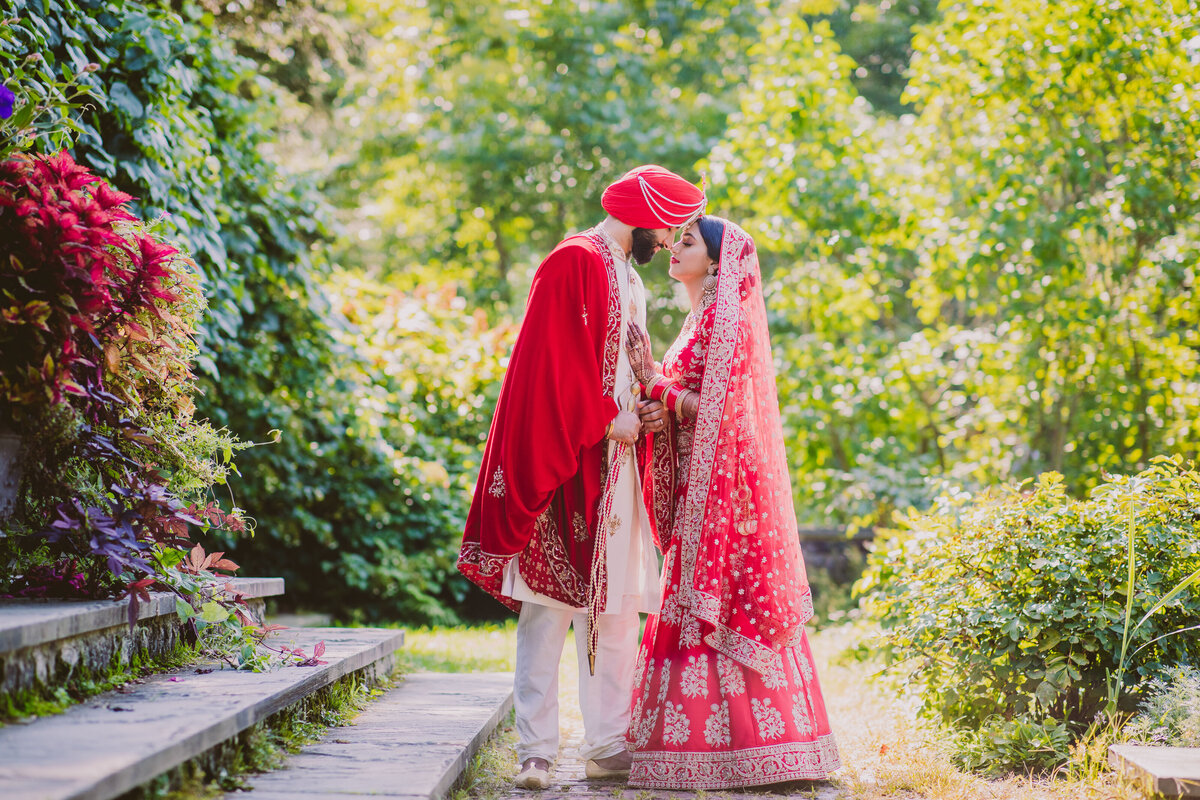 A sikh bride and groom embracing in the planting fields arboretum