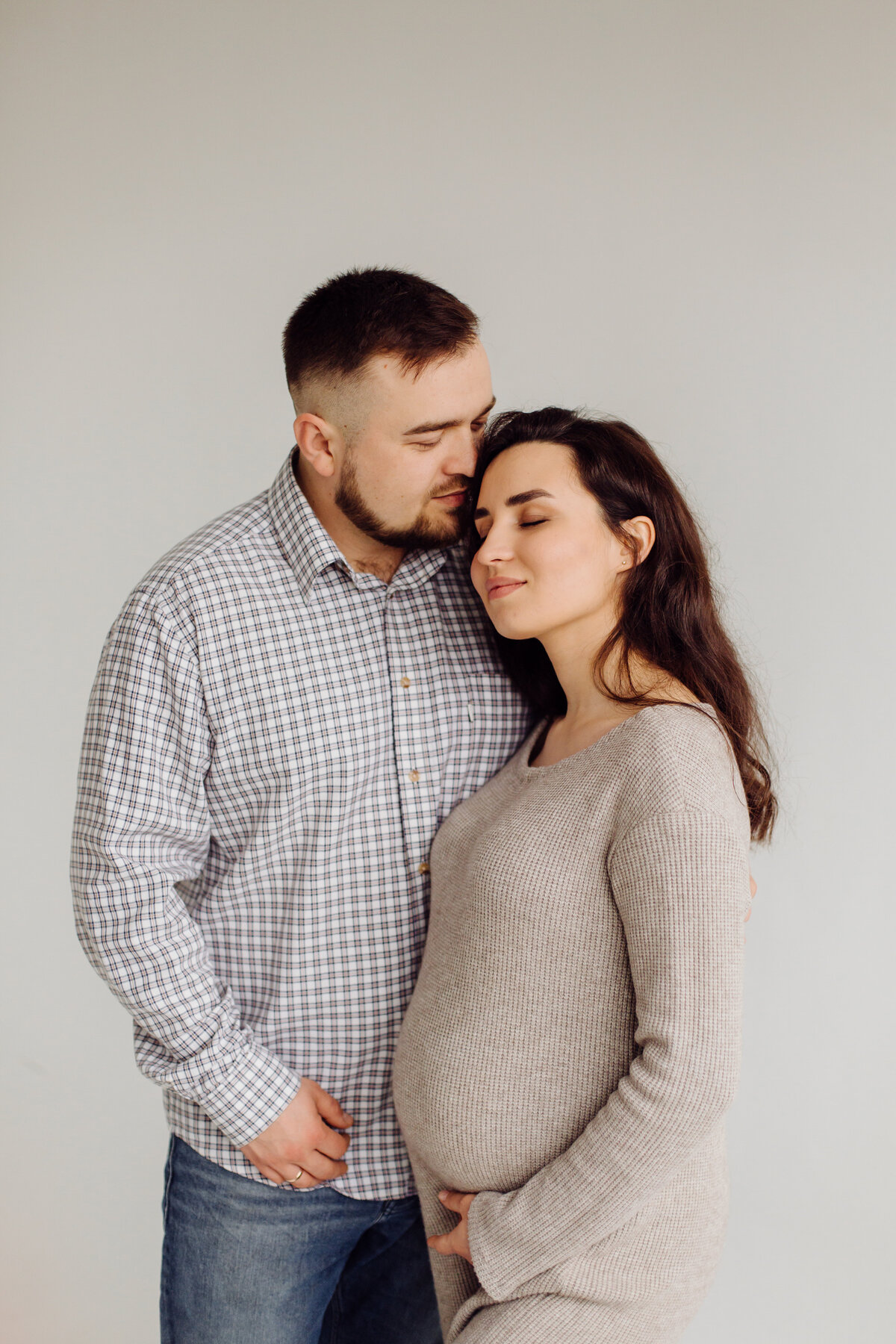 happy-attractive-pregnant-woman-her-husband-posing-studio