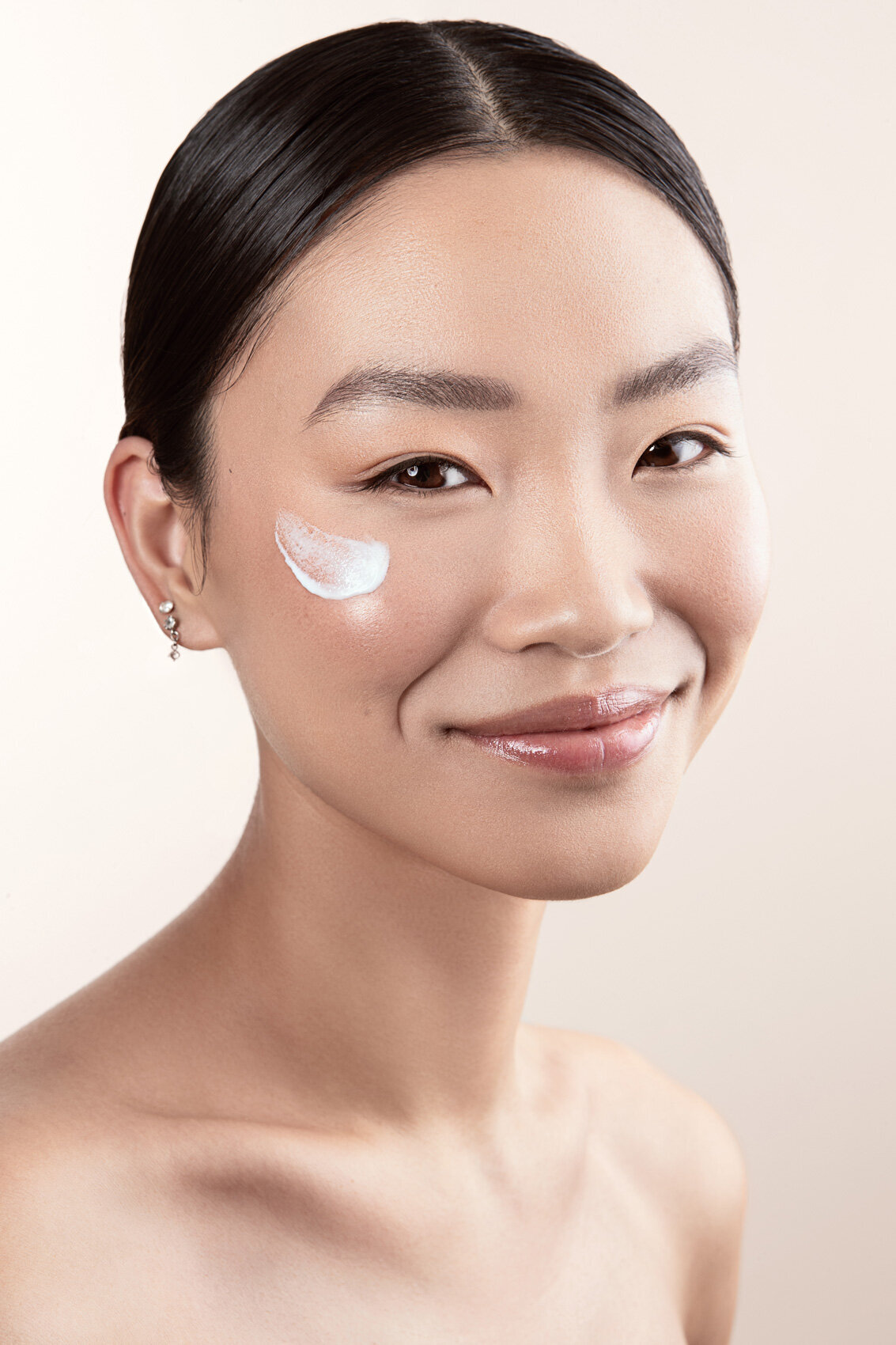 Close-up beauty shot of Jiaqi with glowing skin and bold makeup, photographed by Ylva Erevall.