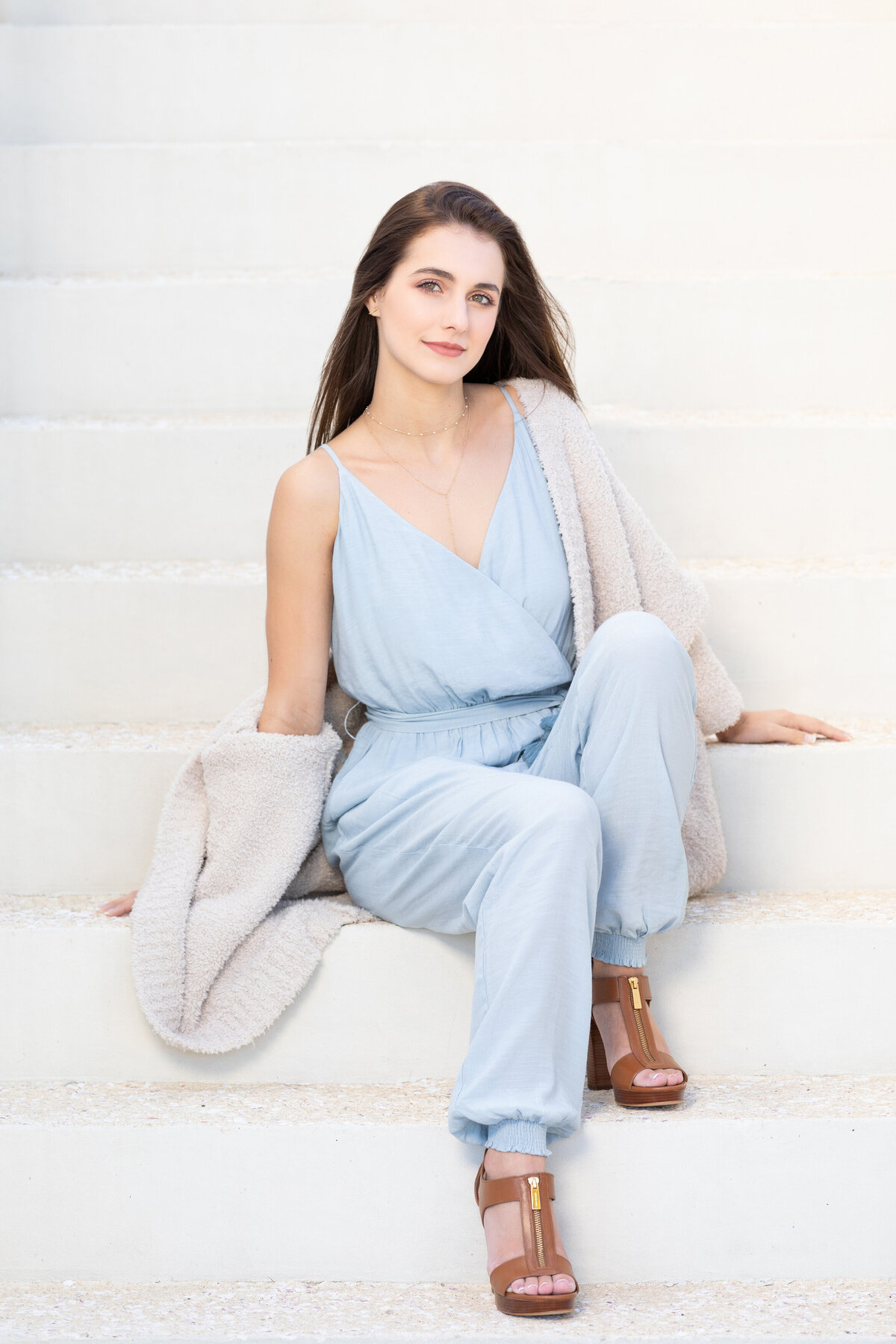 A woman sitting on a white staircase