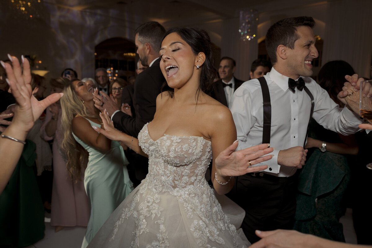 Bride dances on the dancefloor with groom during wedding reception at Belle Mer in Newport.