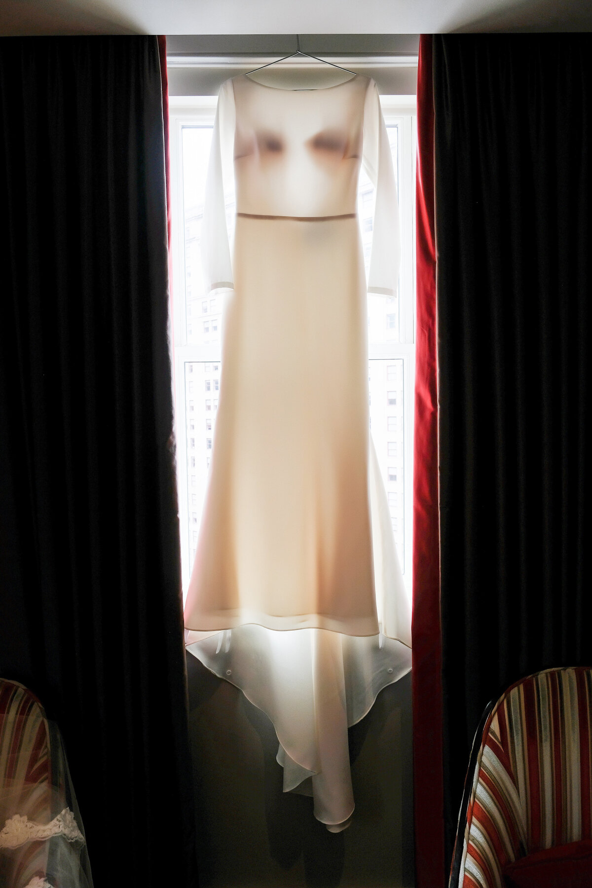 wedding dress hanging in the window with long sleeves