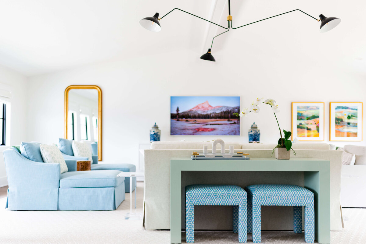 oyster creek studios building belt new build blue chairs and colorful artwork with green side table and stools in living room