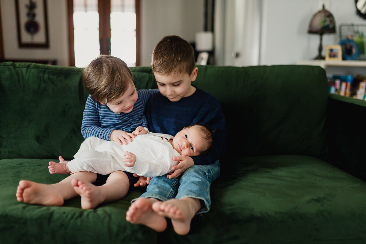 Two young kids holding new Babylon a couch.