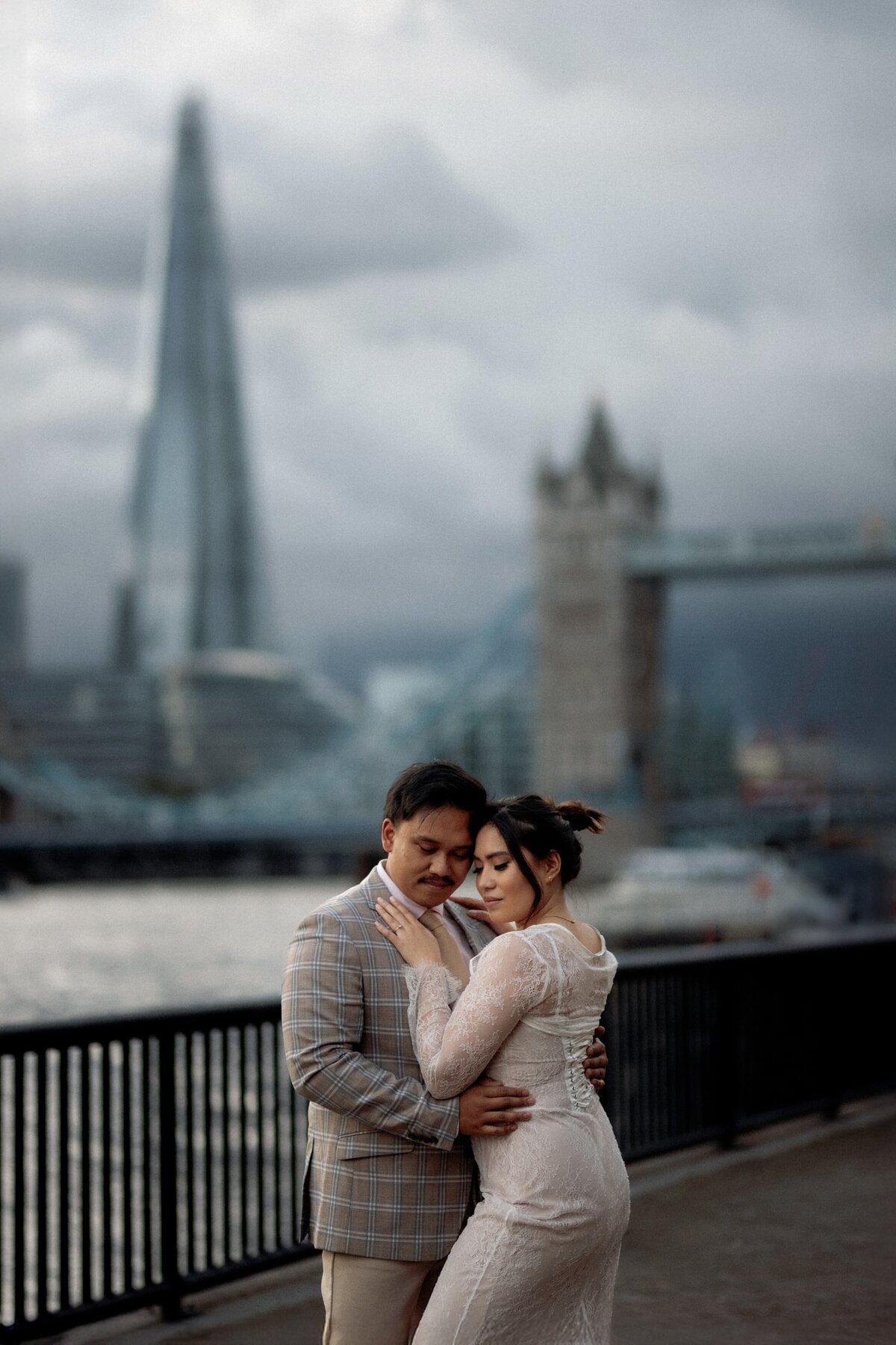 Portrait of couple cuddling eachother during tehir elopement photography in front of tower Bridge and Shard Tower in the background
