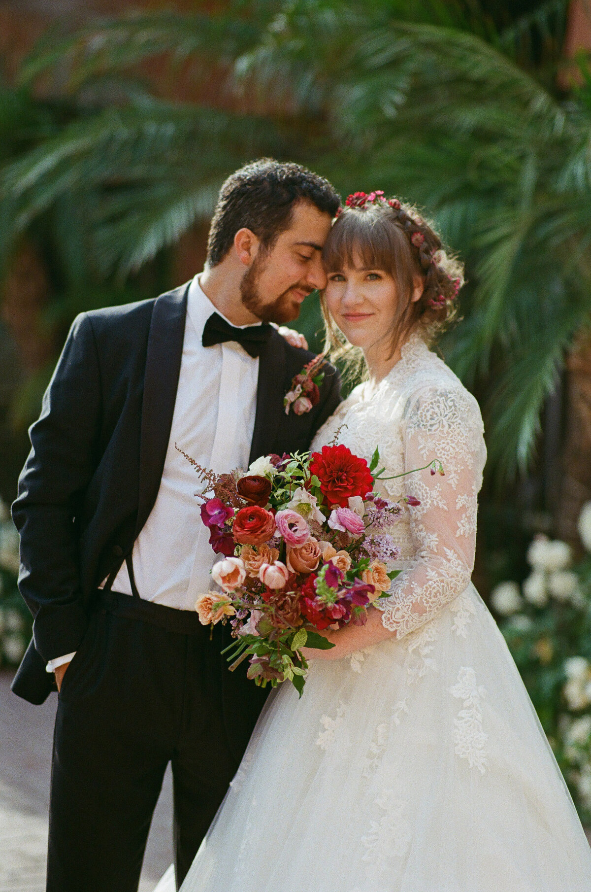 A groom resting his head on his bride's forehead.